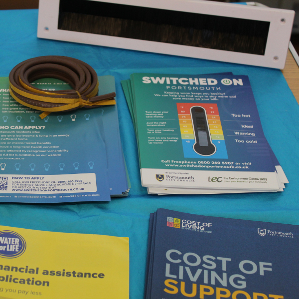 leaflets with switched on portsmout branding, a thermometer card that shows the temperature of a room and a draught exluder